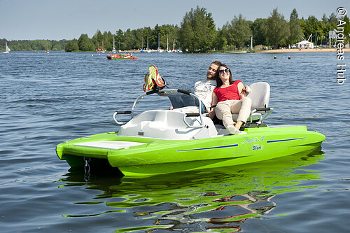 Ein Paar genießt die Sonne auf einem Pedelec-Tretboot am kleinen  Brombachsee. Da in dem Boot ein kleiner Elekromotor eingebaut ist, können die beiden ganz ohne Anstrengug auf dem See fahren.