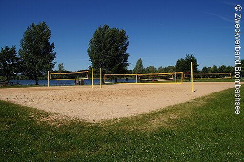 Beachvolleyball-Felder in unmittelbarer Seenähe am Großen Brombachsee bei Enderndorf. Im Hintergund ein strahelnd baluer Himmel und einzekne grüne Bäume.