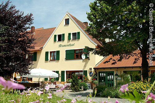 Die gelbe Fasse mit grünen Fensterläden und der Biergarten des Gasthofes "Blumenthal" im fränkischen Baustil in Wernfels in der Nähe von Spalt.
