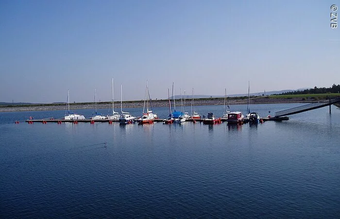 Ein Segelhafen im blauen See. Nur wenige Boote liegen im Hafen.
