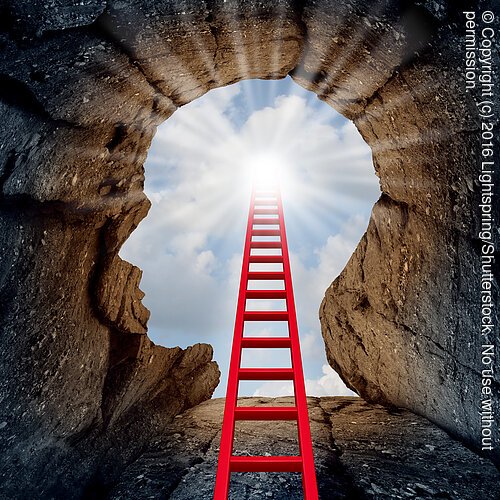 Concept of open mind as a a deep mountain cliff shaped as a human head with a ladder leading to the outside towards a glowing sun as a psychology and mental health metaphor for spiritual discovery.